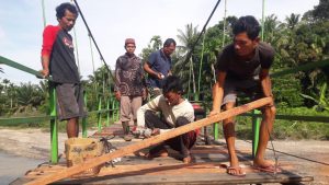 Masyarakat Kubu Anau Goro Perbaiki Lantai Jembatan Gantung